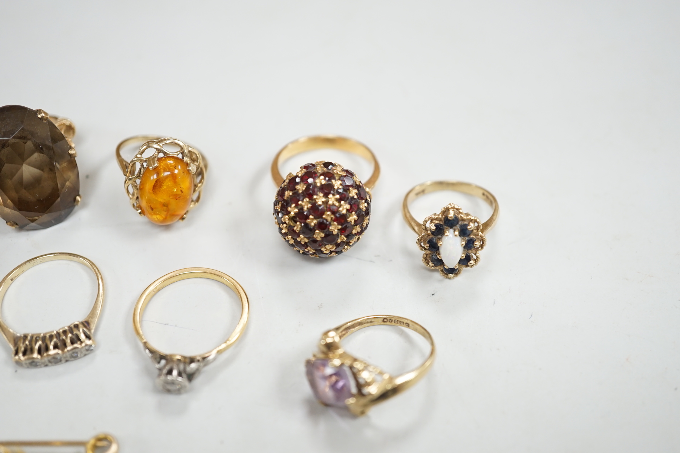Two yellow metal and illusion set diamond rings, two 9ct gold and gem set rings, two yellow metal and gem set rings and two brooches, including 9ct mounted cameo shell.